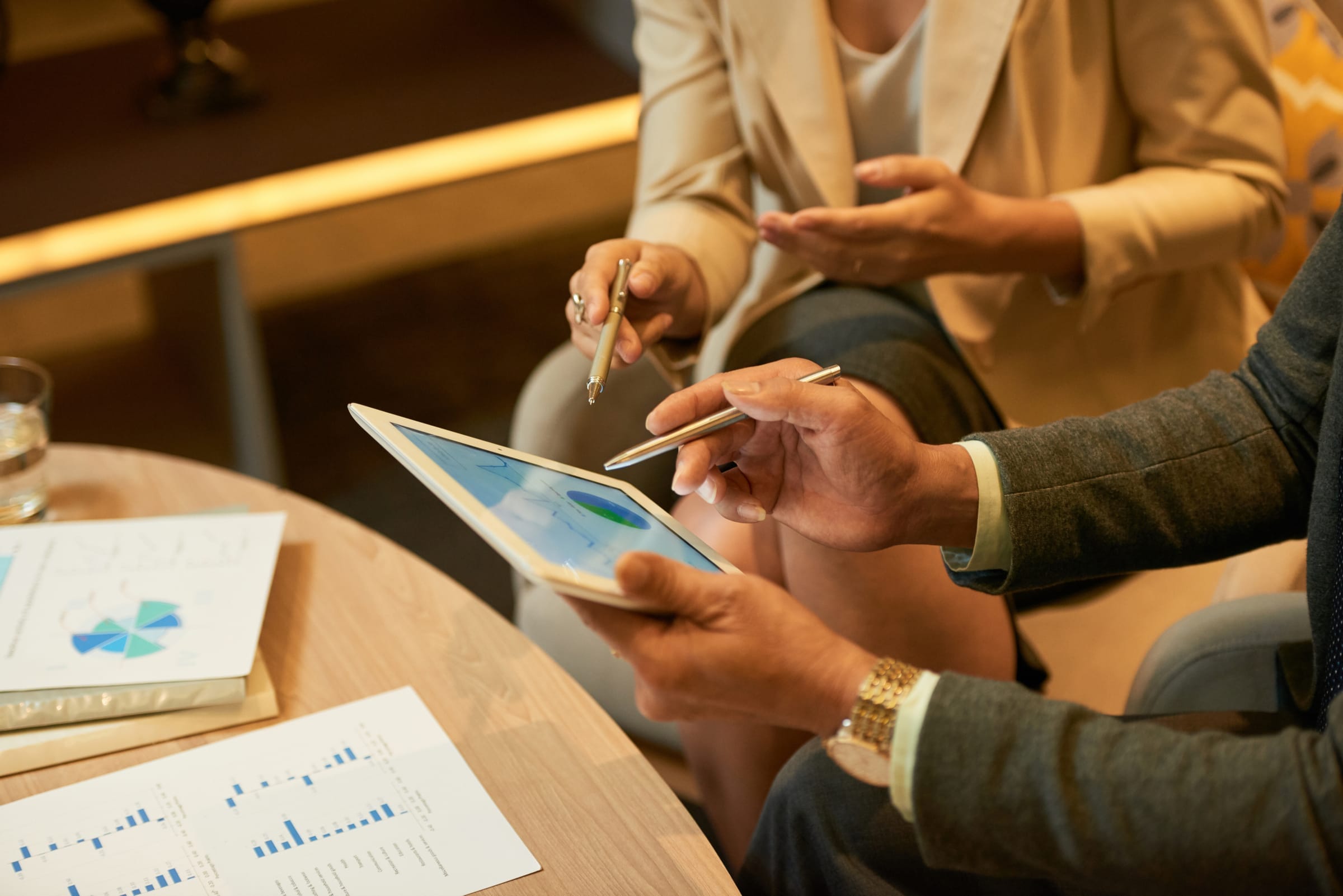 Réunion entre deux personnes étudiant un tableau de bord d'achats sur tablette