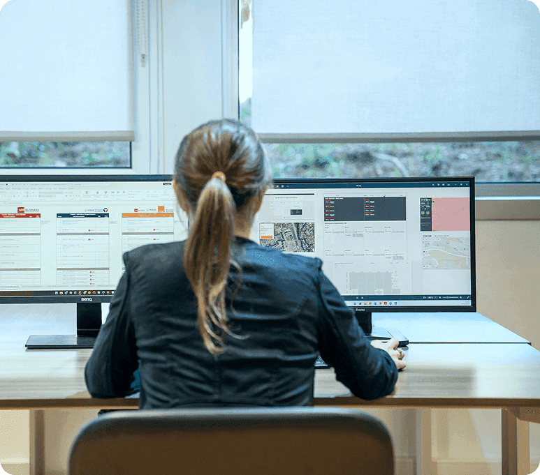 Salariée concentrée devant ses écrans en analyse des dépenses indirectes